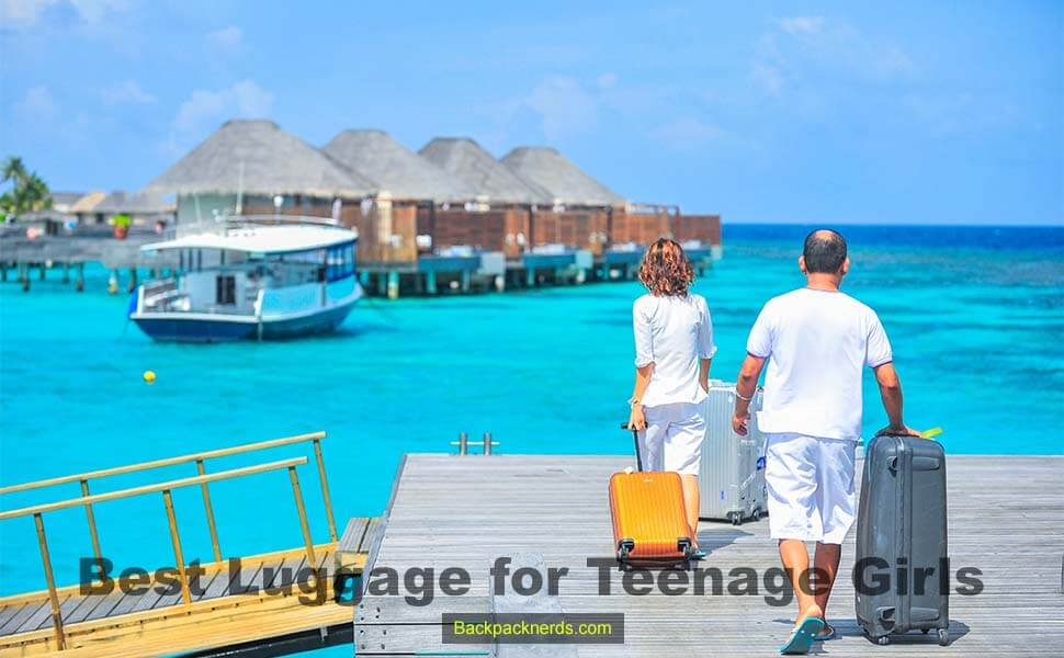 a man and a woman walking to the blue sea beach with luggage(Best Luggage for Teenage girls)