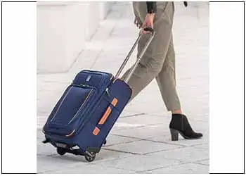 A woman carrying a Rollaboard luggage